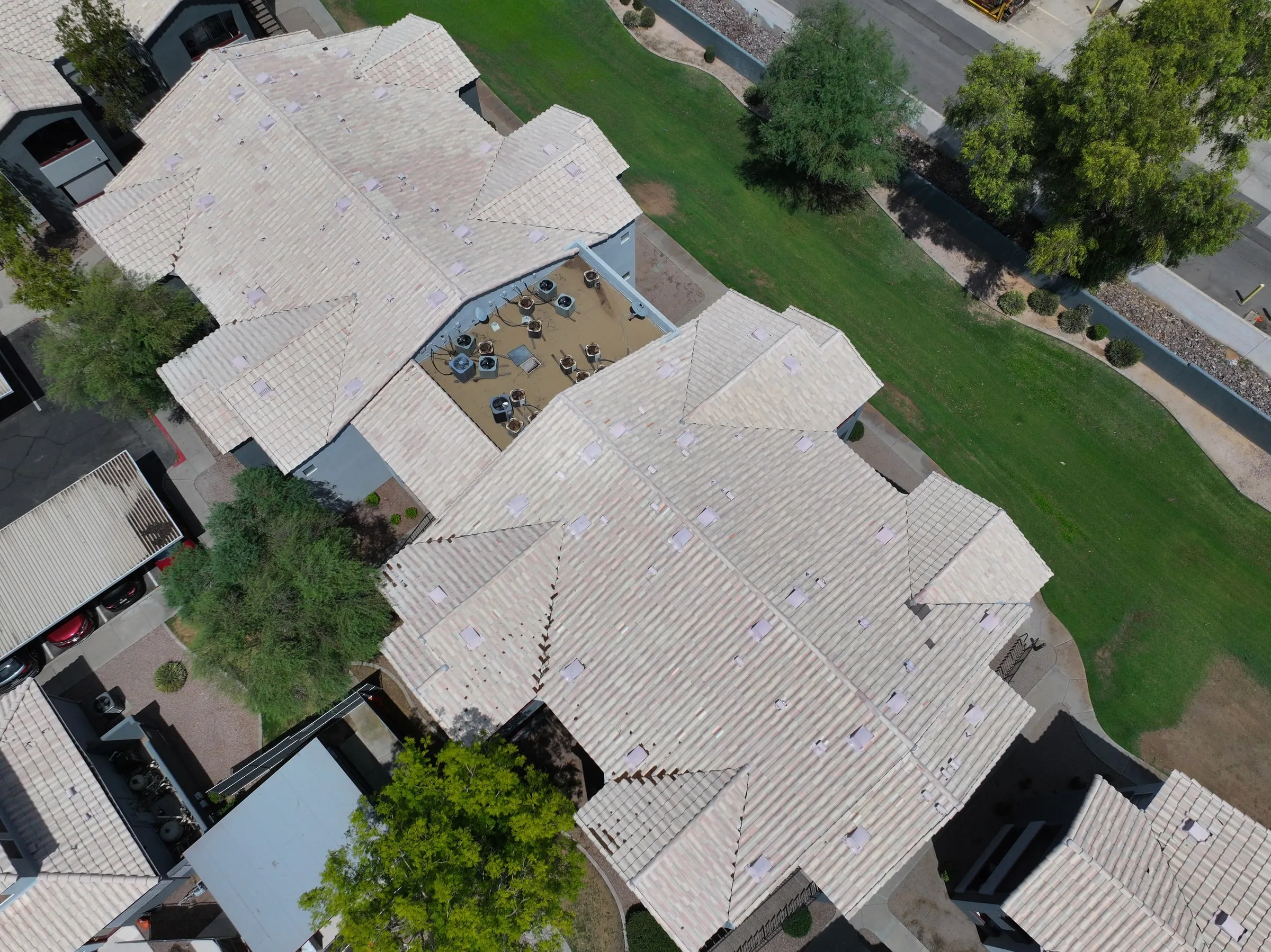 Overhead aerial view of a light-colored tile roof on a multi-unit property